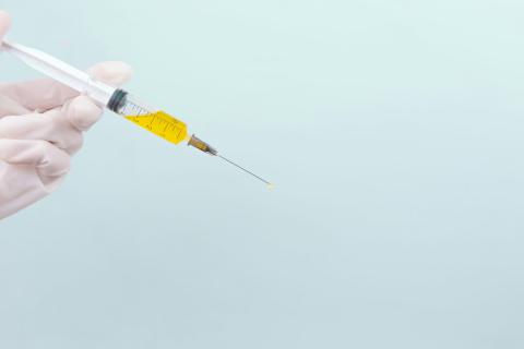 image of gloved hand holding syringe