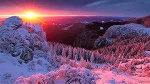 sun rising over a snowy landscape 