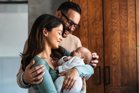 Two parents hold their offspring.