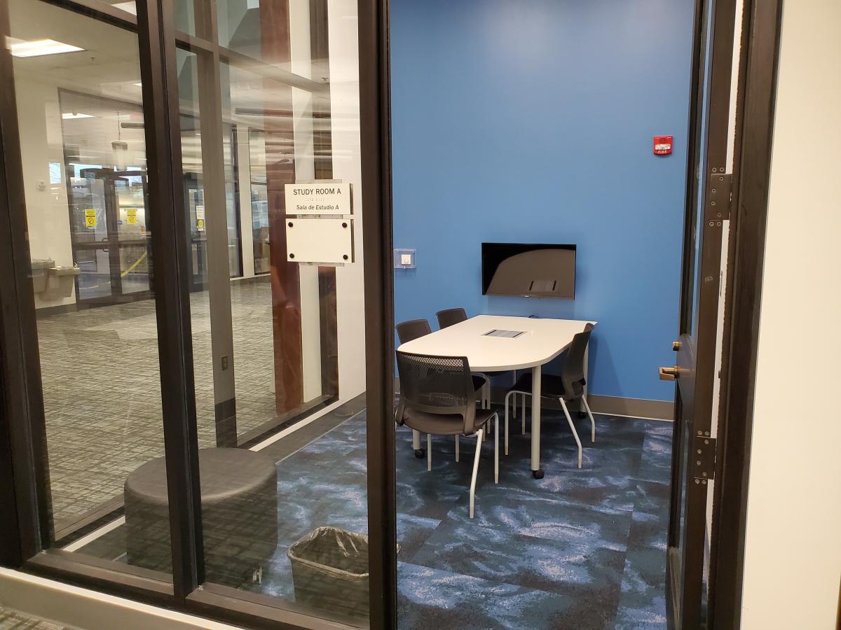 Photo of Study Room A, showing a table with 4 chairs and a wall-mounted television.