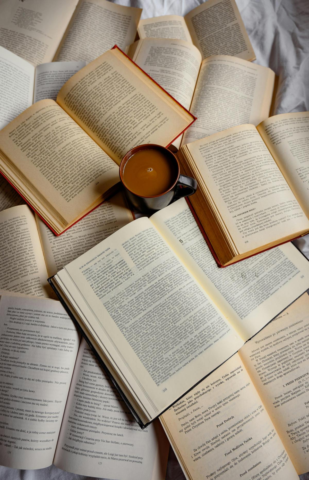 cup of cocoa surrounded by open books 