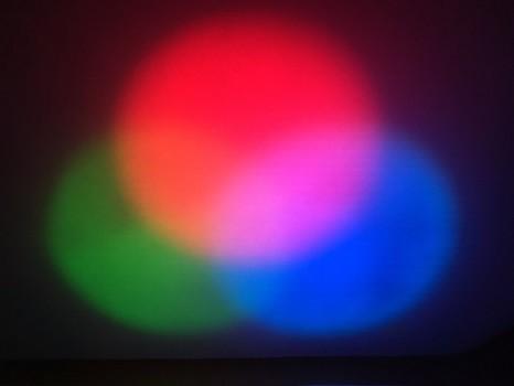 Circles of red, green, and blue light on a black background.