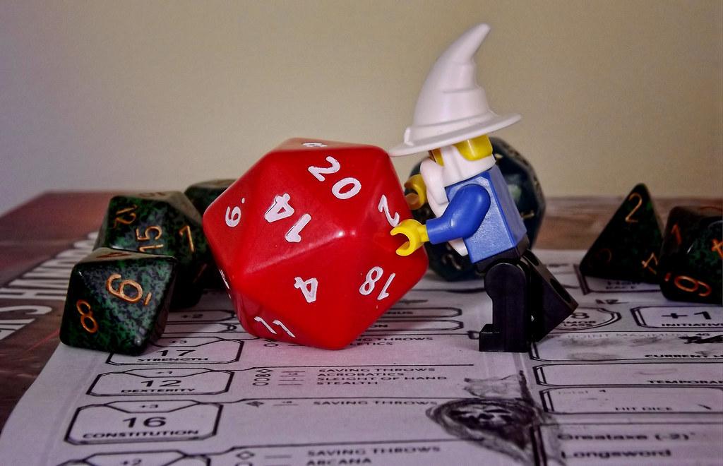 Picture of a lego wizard pushing a d-20 